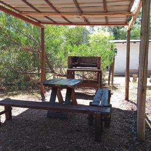 a picnic table and a bench under a pavilion at Casa a 100 nts del mar in Balneario Argentino