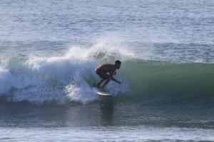 a man riding a wave on a surfboard in the ocean at HOUSEWAVe in Parrita