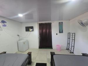a room with two beds and a brown door at HOUSEWAVe in Parrita