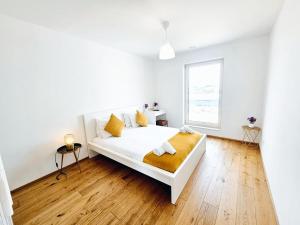 a white bedroom with a bed and a window at Relaxed City 1BR Apartment in Luxembourg +5 photos
