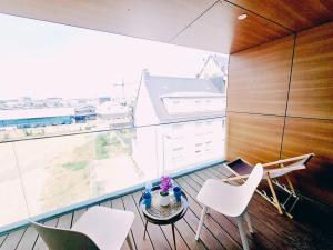 a balcony with a table and chairs and a large window at Relaxed City 1BR Apartment in Luxembourg