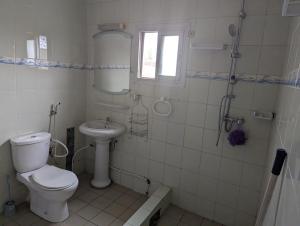 a bathroom with a toilet and a sink at Appartement Meublé 3 Chambres in Douala +9 photos