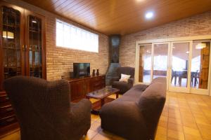 a living room with a couch and chairs and a tv at La Vinya de Mas Pujol in Suria