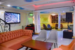 a waiting room with a couch and a tv at lynna hôtel in Yaoundé
