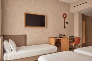 a hotel room with two beds and a desk and a television at Il Leon D'Oro Bari - by Farace Hotels in Bari +50 photos