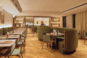 a dining room with tables and green chairs at Il Leon D'Oro Bari - by Farace Hotels in Bari