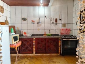 a kitchen with a stove and a microwave at Nascimento BEACH in Águas Belas
