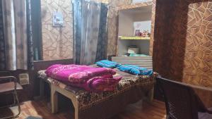 a table with purple blankets on it in front of a mirror at Siddhi's Inn in Prayagraj +5 photos