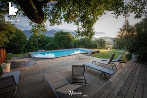a deck with chairs and a swimming pool at Domaine De Blancardy in Moulès-et-Baucels