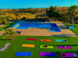 a swimming pool with colorful mats on the grass at VILLA Casa Eden in Vila Nova De Cacela