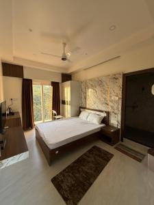 a bedroom with a bed and a flat screen tv at Xsquare Hotel in Garubhāsa +9 photos