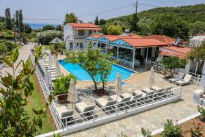 a resort with a swimming pool with chairs and umbrellas at VILLA ROSA in Troulos