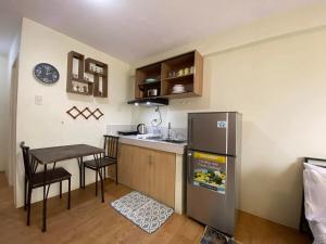a small kitchen with a table and a refrigerator at Chic Studio near Ocean Park in Cebu City