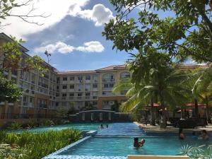 a pool at the resort with people in the water at Chic Studio near Ocean Park in Cebu City