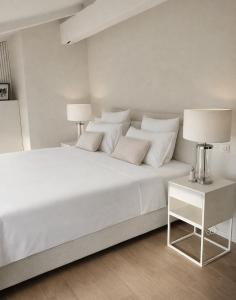 a white bedroom with a white bed with two lamps at Refuge Luxe - Boutique Guesthouse (Adults only - Gay-friendly) in Camiran +41 photos