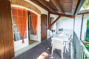 a porch with a white table and chairs on it at Vear apartments - Lido di Volano in Lido di Volano