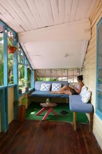 a woman sitting on a couch in a room at The Bocas Corner in Bocas Town