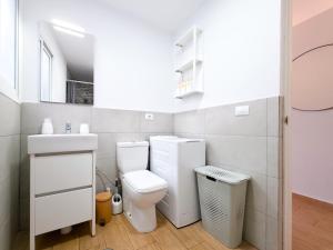 a white bathroom with a toilet and a sink at Verana House in Arguineguín +10 photos