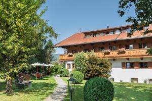 a building with a garden in front of it at Landhaus Christl am See in Bad Wiessee