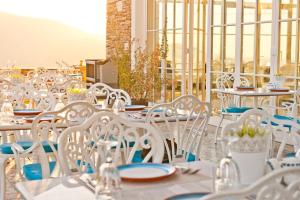 a group of white chairs and tables on a balcony at Vinifera Ephesus Hotel in Selçuk