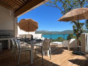 a patio with a table and chairs and umbrellas at Villa Fautea Verdon in Sainte-Croix-de-Verdon