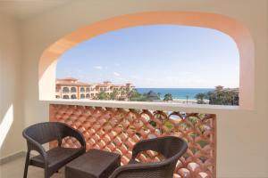 a balcony with two chairs and a view of the ocean at Royal Solaris Los Cabos - All Inclusive in San José del Cabo