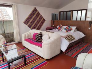 a living room with a couch and a bed at Titicaca Sariri Lodge in Puno
