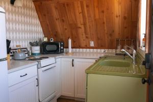 a kitchen with a sink and a microwave at The Cozy Owl A-Frame in Jefferson +10 photos