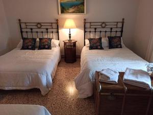 a bedroom with two beds and a lamp on a table at Canto del DORMILERO in San Cristóbal de la Vega +12 photos