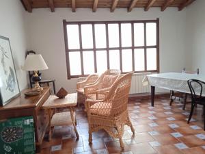 a room with wicker chairs and a table and a desk at Canto del DORMILERO in San Cristóbal de la Vega