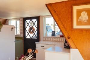 a kitchen with a staircase and a door with a dog picture at The Cozy Owl A-Frame in Jefferson