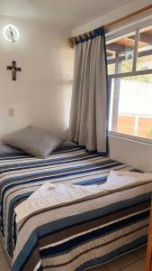 a bed in a room with a window at Hotel Calli Yoloiztac, Valle de bravo in Valle de Bravo