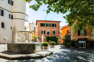 a fountain in the middle of a courtyard with buildings at FRASCATI Suites in Frascati