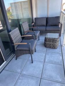 a patio with chairs and a couch on a balcony at Madison A in Westende
