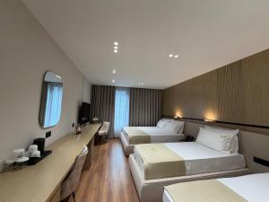 a hotel room with two beds and a mirror at Rich Hotel in Pogradec