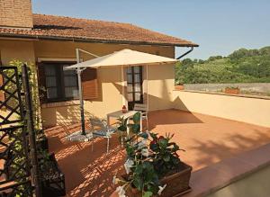 a patio with an umbrella and a table and chairs at Agriturismo Polgara in Lari