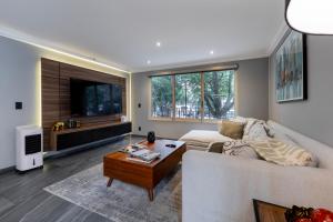 a living room with a white couch and a table at Capitalia Obelisk Polanco in Mexico City