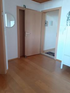 an empty room with a door and a wooden floor at Gästewohnung in Parkstetten bei Straubing in Parkstetten