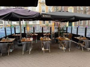 a restaurant with tables and chairs under an umbrella at Bella Vita Hotel Restaurant in The Hague