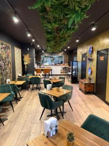 a restaurant with wooden tables and green chairs at Bella Vita Hotel Restaurant in The Hague