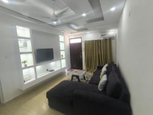a living room with a couch and a tv at NyaliHomes in Mombasa +3 photos