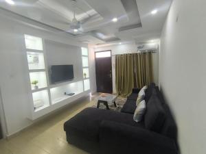 a living room with a couch and a tv at NyaliHomes in Mombasa