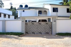a white house with a gate and a garage at NyaliHomes in Mombasa