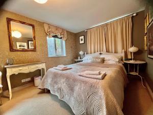 a bedroom with a large bed with two towels on it at Orchard Paddocks in Guildford