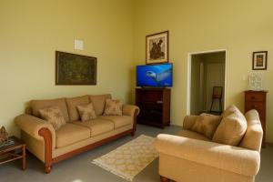a living room with two couches and a flat screen tv at Coming Home in Mount Nesbit
