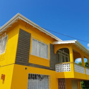 a yellow house with a black at Coming Home in Mount Nesbit