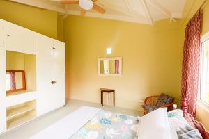 a bedroom with yellow walls and a bed and a window at Coming Home in Mount Nesbit