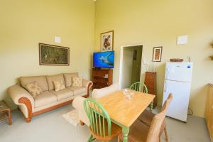 a living room with a couch and a table at Coming Home in Mount Nesbit