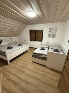 two beds in a large room with wooden ceilings at Apartmany Zvole in Zvole