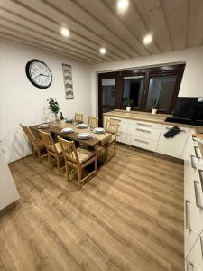 a dining room with a table and chairs and a clock at Apartmany Zvole in Zvole +9 photos